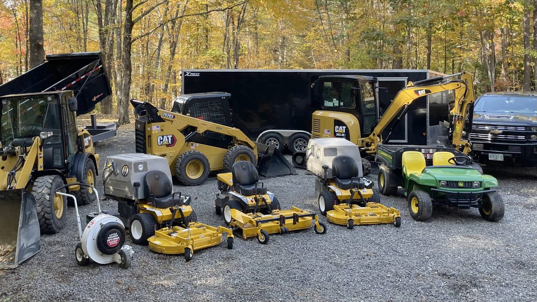 The LandPro fleet lined up on gravel in front of fall foliage