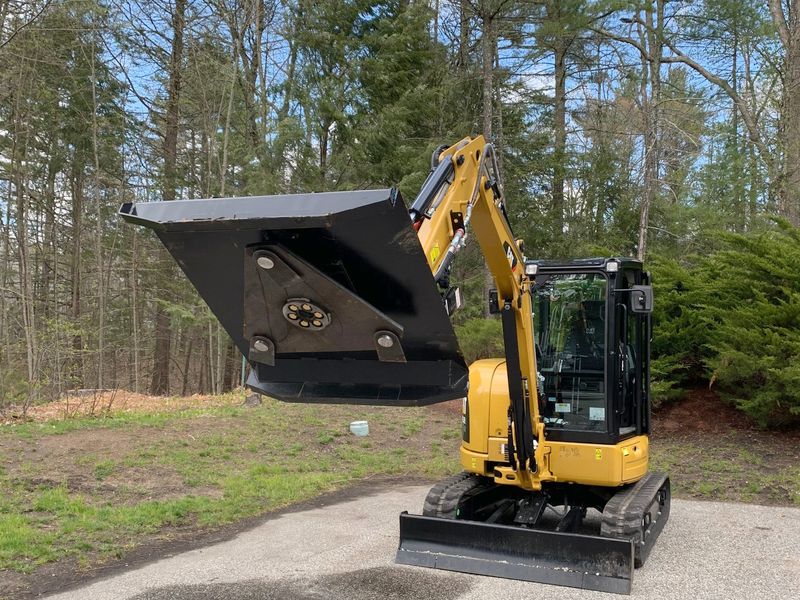 Rotary brush cutter deck raised on the mini excavator